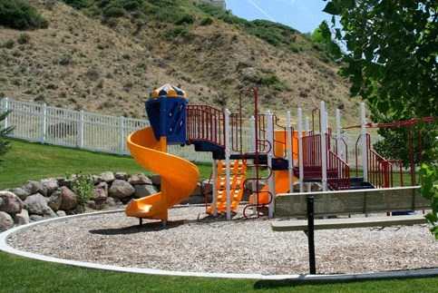 Colorful playground with orange slide and climbing equipment at Liberty Hill Apartments, Draper, UT