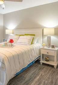 A bedroom with a bed, nightstand, and two lamps.