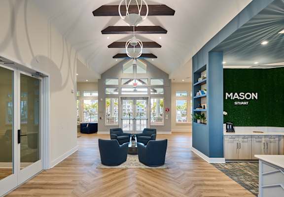 a lobby with blue chairs and a green wall and glass doors