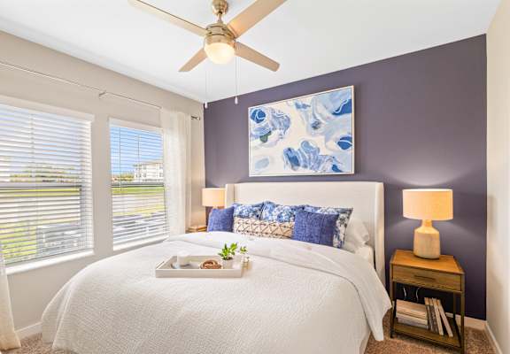 a bedroom with a large bed and a ceiling fan
