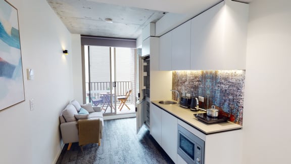 a kitchen with a counter top and a living room with a balcony