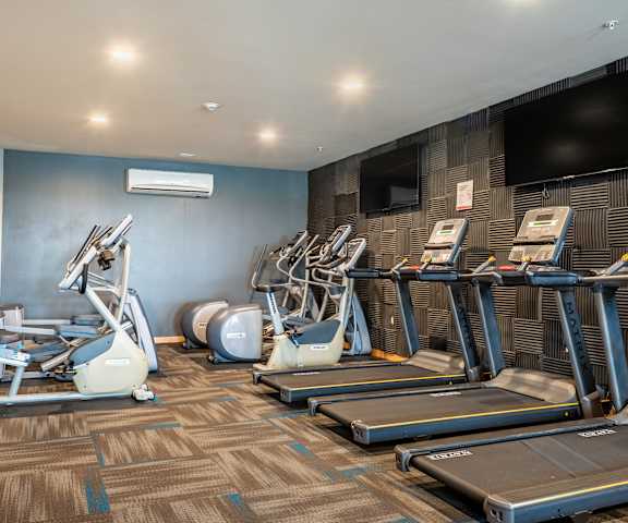 A spacious gym with TVs, weights, treadmills, elliptical machines, and other exercise equipment at the View at Pinnacle Peak Apartment homes. 