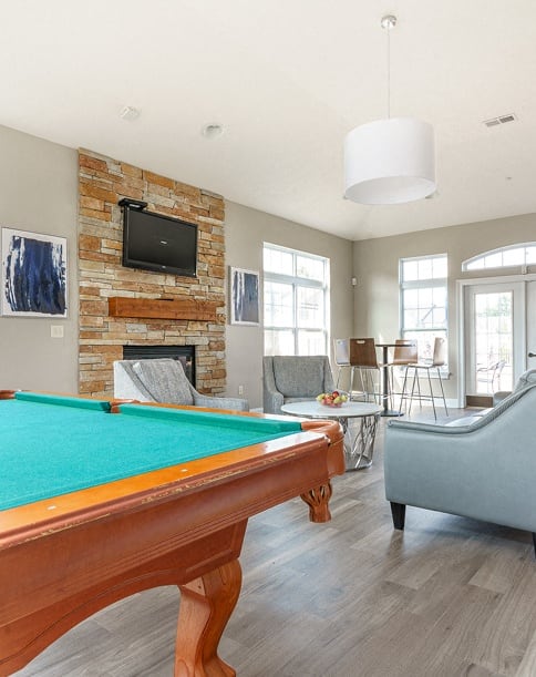 a living room with a foosball table and a green couch
