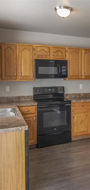 a kitchen with white cabinets and a black stove and refrigerator