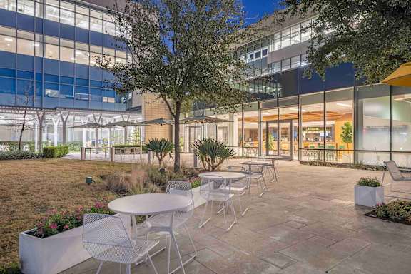 A patio with tables and chairs is set up outside a building.