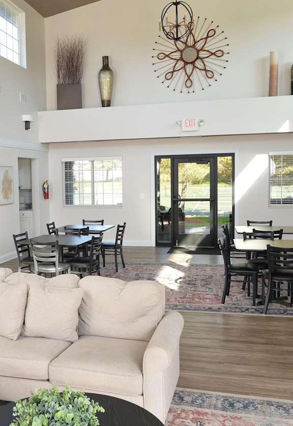 a large living room with a white couch and a dining room table