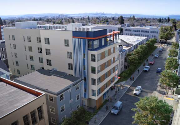 an aerial view of an apartment building with people walking on the sidewalk and cars parked on the