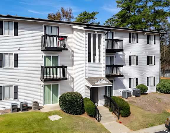 a white apartment building with balconies and a green door at Tucker Square, Stone Mountain