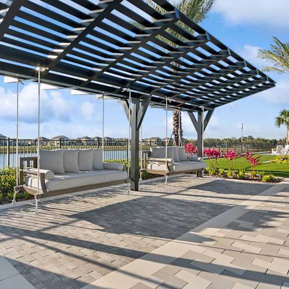 A patio with a white bench and a black metal structure.