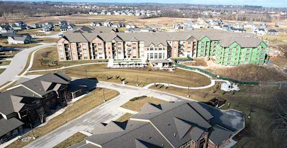 A large building complex with a green building in the background.