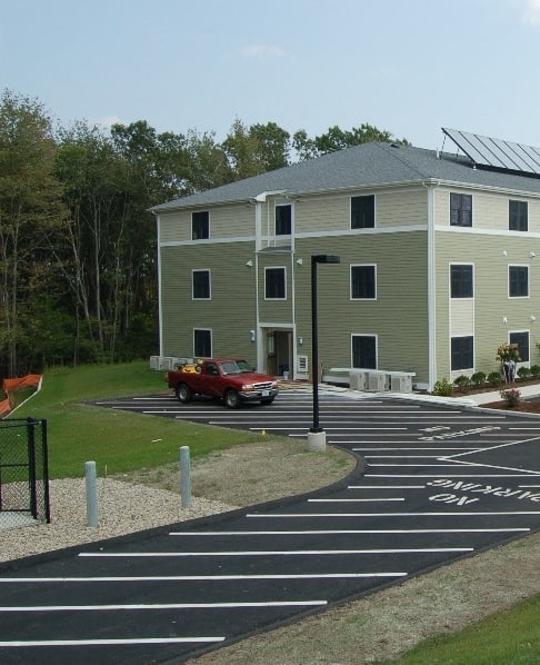 a building with solar panels on the roof and a parking lot