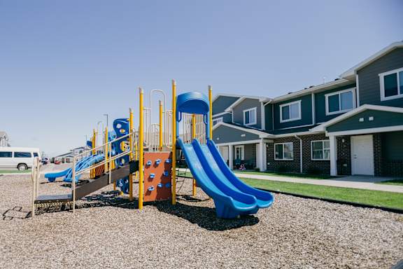 A playground with a blue slide and a yellow structure.