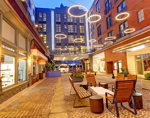a street with tables and chairs and buildings in the background