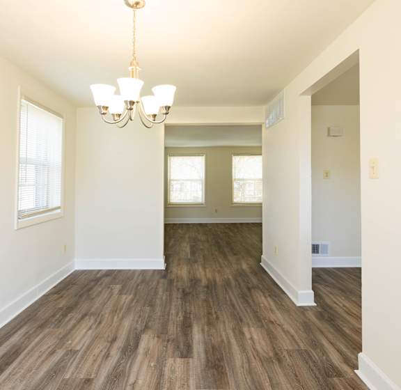 an empty living room with a chandelier