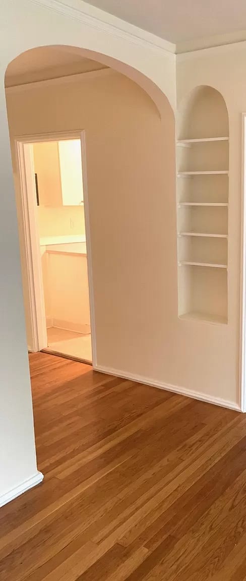 an empty room with a wooden floor and a closet