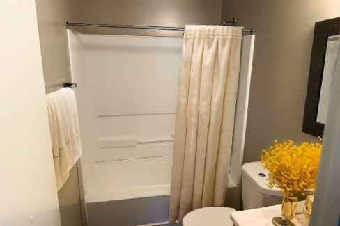 A white bathroom with a towel hanging on the wall.