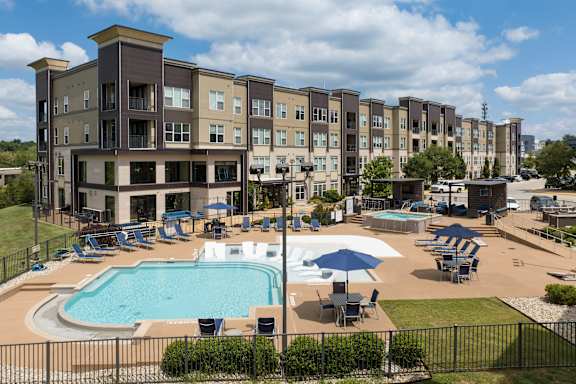 A large apartment complex with a pool and a hot tub.