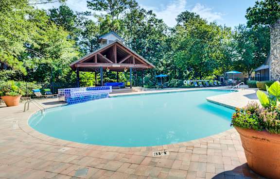 a living room with a fireplace and a pool in the background at High Ridge Apartments in Athens, Georgia
