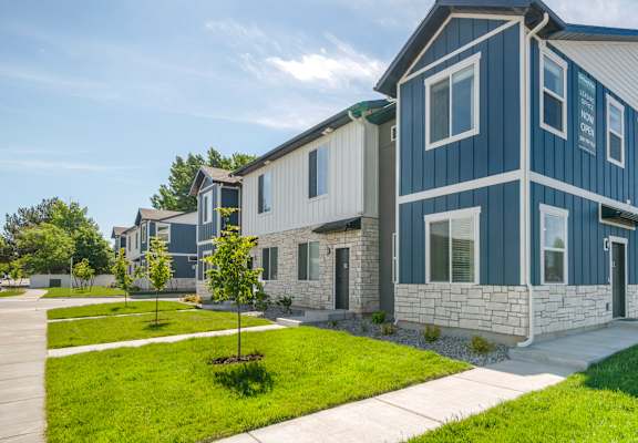 A row of modern houses with blue siding and white trim.