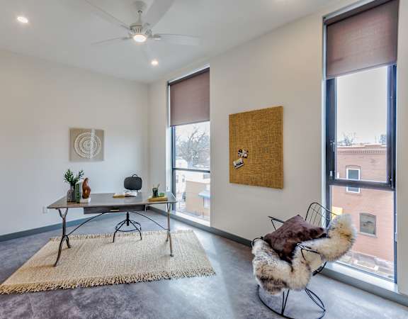 A room with a table, chairs, and a rug.