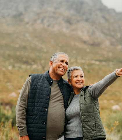 a man and a woman standing in a field pointing to a mountain at Mariposa at Westchester, Grand Prairie
