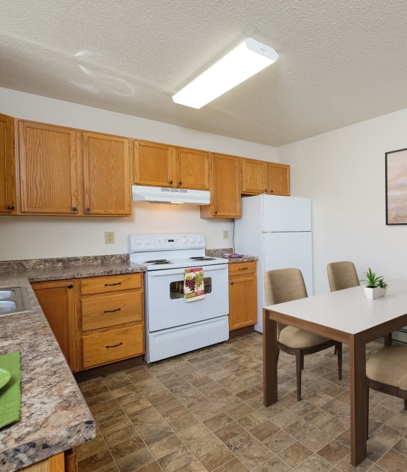 a kitchen with white appliances and a dining table with chairs