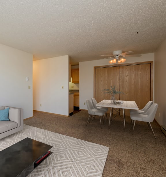 Fargo, ND Windgate Apartments | Living a living room and dining room with a couch and a table