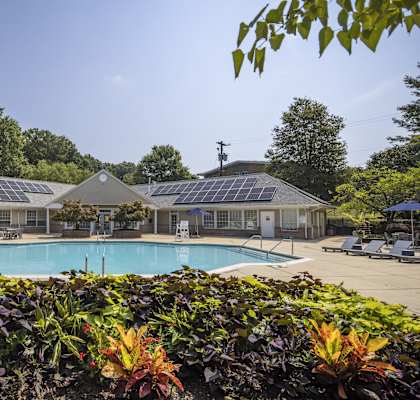 a swimming pool with solar panels on the side of a building at Autumn Woods, Bladensburg, MD