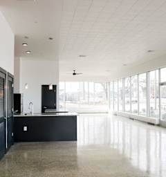 A kitchen with black cabinets and a large island with a sink.