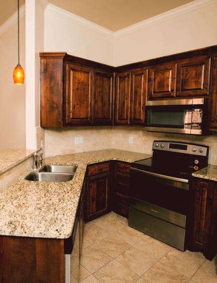 a kitchen with wooden cabinets and granite counter tops