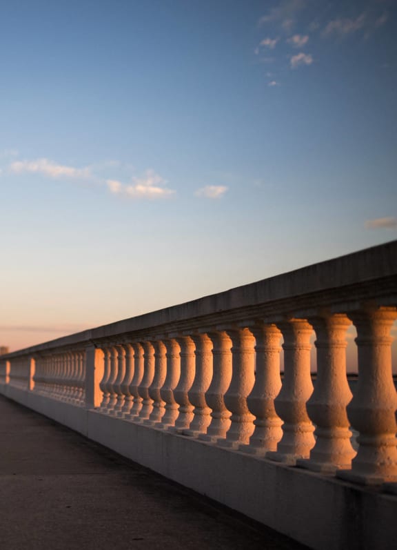 a woman walking on a wooden pathway at sunset