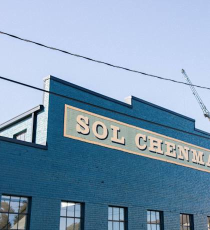 an old sign on the side of a blue brick building