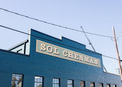 an old sign on the side of a blue brick building