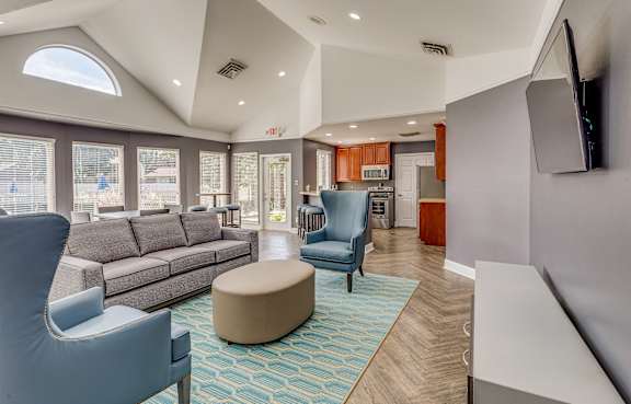 A clubhouse with a blue chair and a brown ottoman at Deerfield Woods Apartments, Michigan