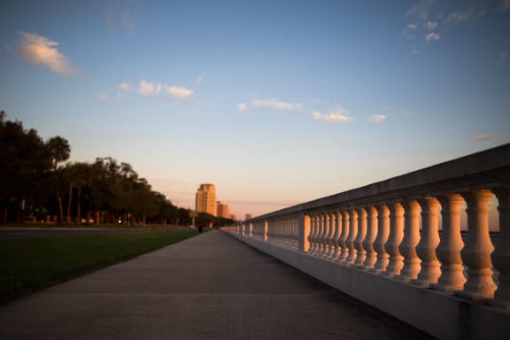 a row of columns on the side of a bridge at sunset