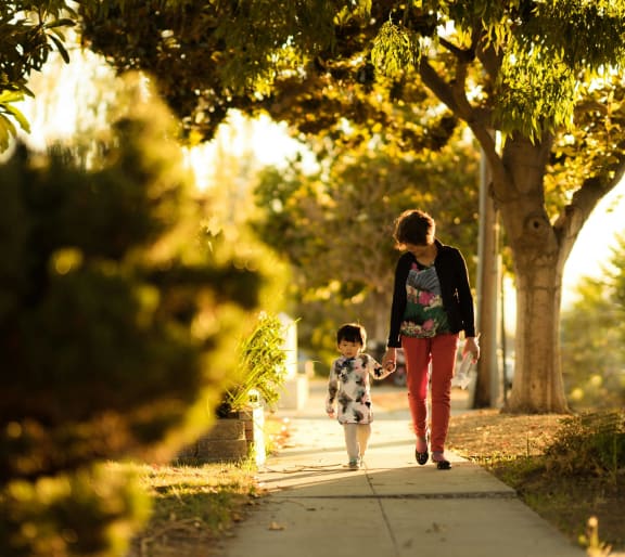 a woman and a child walking down a sidewalk