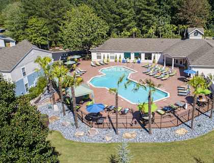 a aerial view of a pool with chairs and umbrellas