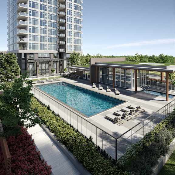 A modern building with a pool and lounge chairs.