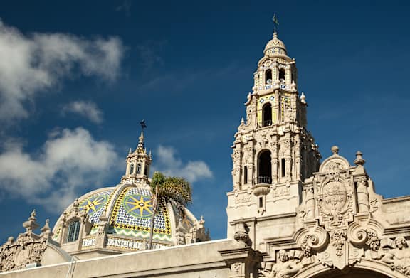 A large ornate building with a clock tower and a dome with a mosaic design.