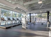 Thumbnail 18 of 24 - A gym with treadmills and exercise equipment.