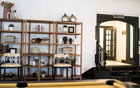 A room with a shelf and a chair in front of it.