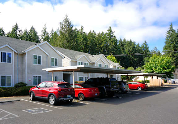 A parking lot with cars and a building in the background.