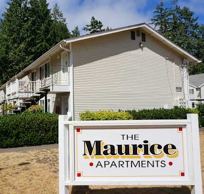 A sign for The Maurice Apartments is in front of a building.