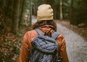 Thumbnail 9 of 16 - A person is walking in a forest at Red Rock Apartments, South Dakota