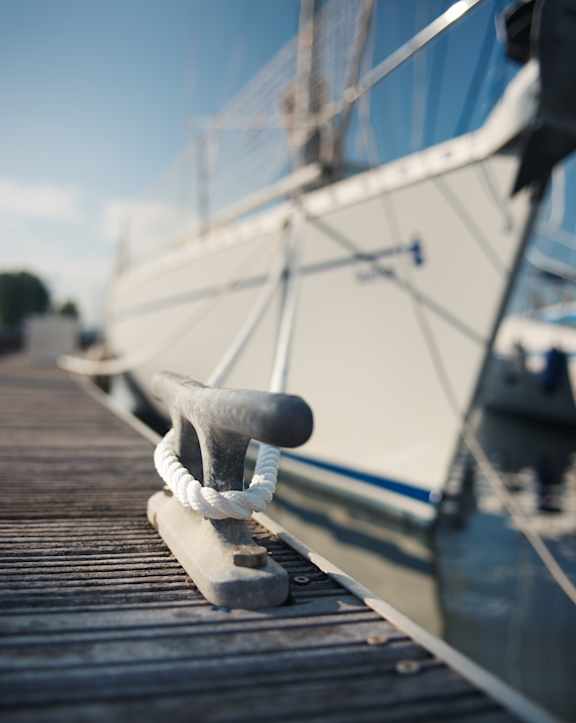 A rope tied to a cleat on a dock.