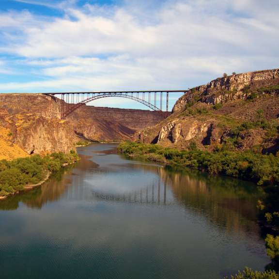 A bridge spans across a river in a canyon.
