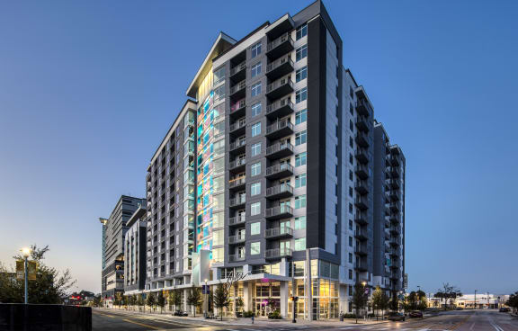 an exterior view of a building at dusk with a blue sky in the background