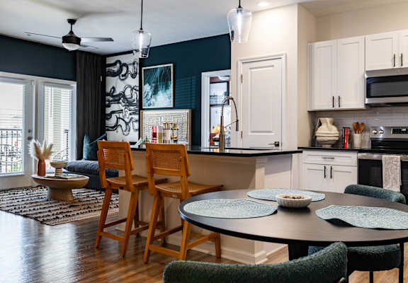 A kitchen with a table and chairs in front of it.