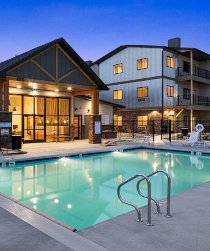 a swimming pool at night in front of a building at The Expo, Montana, 59106