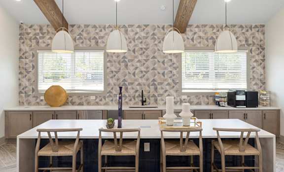 A kitchen with a table and chairs in front of a patterned wallpapered wall.